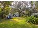 Expansive backyard featuring lush greenery, mature trees, and a storage shed at 620 Scotland St, Dunedin, FL 34698