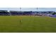 A sunny view of a green baseball field with players and fans in the stands on a clear day at 620 Scotland St, Dunedin, FL 34698