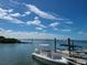 Boats are docked along a wooden pier on a sunny day at Dunedin marina with cloudy skies at 620 Scotland St, Dunedin, FL 34698