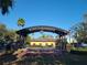An outdoor stage structure with brick base and metal archway in Dunedin's Pioneer Park at 620 Scotland St, Dunedin, FL 34698