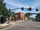 Street view shows a building at a crosswalk with businesses and signs on a partly cloudy day at 620 Scotland St, Dunedin, FL 34698