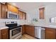 Modern kitchen with stainless steel appliances, white countertops, and wood cabinets at 6905 122Nd Dr, Largo, FL 33773