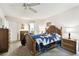 Bright bedroom with a ceiling fan and a queen bed with blue and white quilt at 7400 Sun Island S Dr # 207, South Pasadena, FL 33707