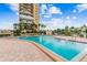 Relaxing community pool with patio furniture and building view at 7400 Sun Island S Dr # 207, South Pasadena, FL 33707