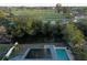 Aerial view of home featuring a pool and solar panels, backing onto a serene waterway and lush green golf course at 746 31St Ne Ave, St Petersburg, FL 33704