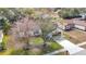 Aerial view of a charming home featuring a well-kept lawn, mature trees and a spacious driveway at 7800 Willow Brook Ct, Hudson, FL 34667