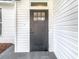 Stylish black front door with glass pane and white siding, welcomes you home at 7800 Willow Brook Ct, Hudson, FL 34667