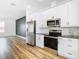 Modern kitchen with stainless steel appliances, white cabinets, and stylish marble backsplash at 7800 Willow Brook Ct, Hudson, FL 34667