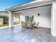 View of the patio with an outdoor dining table, offering backyard views and access to the home's interior at 7800 Willow Brook Ct, Hudson, FL 34667