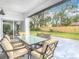 Covered patio featuring an outdoor dining set, with views of the backyard and lush greenery at 7800 Willow Brook Ct, Hudson, FL 34667