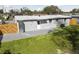 Rear view of a grey single-story home with a well-maintained lawn and fenced yard at 8303 Croton Ave, Tampa, FL 33619