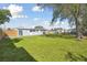 View of the expansive backyard and the exterior of the home beyond the yard at 8303 Croton Ave, Tampa, FL 33619