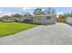 Well-maintained single-story home with a concrete driveway, vibrant lawn, and eye-catching yellow door at 8303 Croton Ave, Tampa, FL 33619