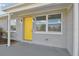 Close-up of the home's stylish yellow front door and modern exterior lighting fixtures at 8303 Croton Ave, Tampa, FL 33619