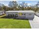 Single story home with a well-manicured lawn, a bright yellow door, and freshly painted grey exterior at 8303 Croton Ave, Tampa, FL 33619