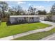 Charming home featuring a lush front yard, freshly manicured plants, and a sidewalk at 8303 Croton Ave, Tampa, FL 33619