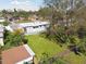 Rear view of a single-story home featuring a spacious, well-maintained lawn bordered by a wooden fence and mature trees at 8303 Croton Ave, Tampa, FL 33619