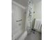 Clean bathroom featuring a shower-tub combo with stylish curtain and white tile at 860 Virginia St # 303, Dunedin, FL 34698