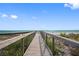 Charming boardwalk leading to a pristine beach with crystal-clear waters and a sunny sky at 860 Virginia St # 303, Dunedin, FL 34698