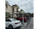 A condo with covered parking featuring white vehicles and manicured landscaping at 860 Virginia St # 303, Dunedin, FL 34698