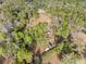 Aerial view of wooded property with a house, outbuildings, and vehicles scattered on the lot at 9445 Preston Rd, Brooksville, FL 34601