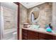 Bathroom with a glass bowl sink, oval mirror, and marbled tile walls at 9445 Preston Rd, Brooksville, FL 34601