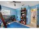 Bright bedroom featuring a ceiling fan, a mural and a desk by the window at 9445 Preston Rd, Brooksville, FL 34601