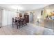 Well-lit dining area features a wooden table with seating for six, tile floors, and an elegant chandelier at 9445 Preston Rd, Brooksville, FL 34601