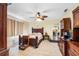 Main bedroom with wood furniture, tile flooring, ceiling fan, and plenty of natural light at 9445 Preston Rd, Brooksville, FL 34601