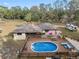 Aerial view of backyard with a pool, deck, and mature trees at 9445 Preston Rd, Brooksville, FL 34601