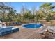 Outdoor in-ground pool with a wooden deck and lounge seating set amongst mature landscaping at 9445 Preston Rd, Brooksville, FL 34601