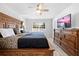 Comfortable bedroom featuring a decorative bedframe, ceiling fan, flat screen television and backyard view at 10340 Ventura Dr, Spring Hill, FL 34608