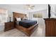 This spacious bedroom features a beautiful carved bed frame, ceiling fan and light wood-look floors at 10340 Ventura Dr, Spring Hill, FL 34608