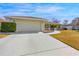 Spacious two-car garage with a wide driveway, complemented by tidy landscaping and a well-maintained lawn at 10340 Ventura Dr, Spring Hill, FL 34608