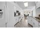 Bright kitchen with white cabinets, stainless appliances, granite counters, and open to dining area at 10340 Ventura Dr, Spring Hill, FL 34608