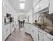 Bright kitchen featuring granite countertops, white cabinets, stainless steel appliances, and an open layout at 10340 Ventura Dr, Spring Hill, FL 34608