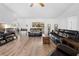 Inviting living room with wood-look flooring, stylish leather furniture, and sliding glass doors to the outdoor space at 10340 Ventura Dr, Spring Hill, FL 34608