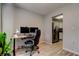 Dedicated office space with wood-look tile floors, desk with two monitors and a view into the kitchen at 10800 Us Highway 19 N # 108, Pinellas Park, FL 33782