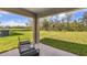Cozy covered patio space overlooking a large lawn with green foliage at 10869 Gentle Current Way, Parrish, FL 34219