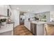 Bright kitchen featuring white cabinets, stainless steel appliances, an island with a marble countertop, and an open floor plan at 10861 Gentle Current Way, Parrish, FL 34219