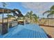 Covered outdoor kitchen on a deck with a built-in grill, counter space, and seating in a backyard space at 12341 79Th Pl, Seminole, FL 33772
