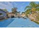 Outdoor entertaining space with deck, BBQ grill and seating in a fenced backyard with palm trees at 12341 79Th Pl, Seminole, FL 33772