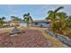 Home with a well-manicured front yard with palm trees, rock, mature landscaping, and a two car garage at 12341 79Th Pl, Seminole, FL 33772