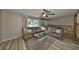Comfortable living room featuring wood floors, cozy seating, and a large window for natural light at 12341 79Th Pl, Seminole, FL 33772