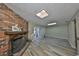 Bright living room with a brick fireplace, skylights, and wood-look floors at 12341 79Th Pl, Seminole, FL 33772