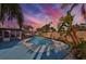 Backyard pool at dusk, with palm trees and landscaping at 12341 79Th Pl, Seminole, FL 33772