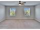 Bright bedroom with carpet, two windows and a ceiling fan at 12973 Dream Catcher Way, Riverview, FL 33579