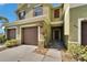 Charming townhome entrance with a private garage, landscaped walkway, and warm, inviting exterior paint at 12973 Dream Catcher Way, Riverview, FL 33579