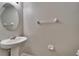 A well-lit powder room with a pedestal sink, round mirror, and modern fixtures at 12973 Dream Catcher Way, Riverview, FL 33579