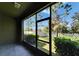 A screened patio with a view to the fenced yard, trees, and blue sky at 12973 Dream Catcher Way, Riverview, FL 33579